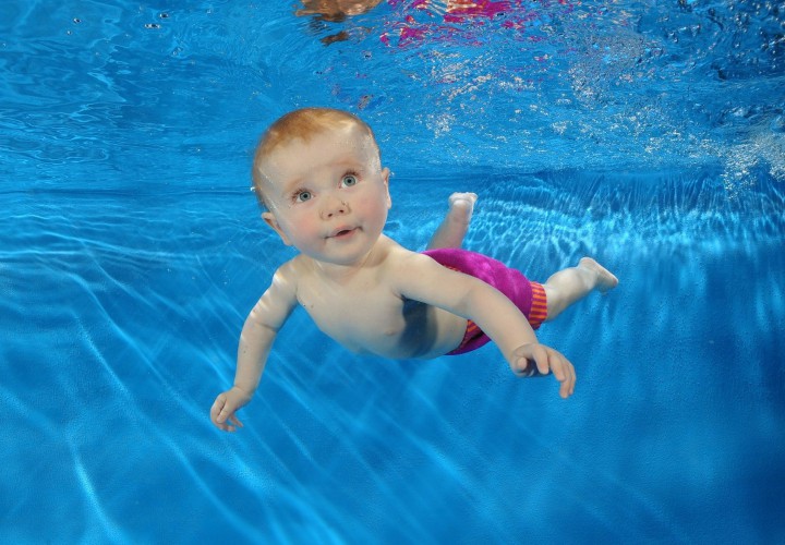 baby swimming in a blue hawaiian pools of michigan pool