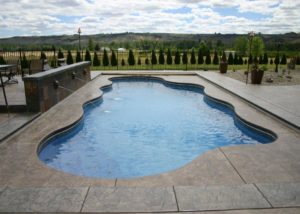 Blue Hawaiian Pools of Michigan Caribbean with waterfall and stamped and dyed concrete