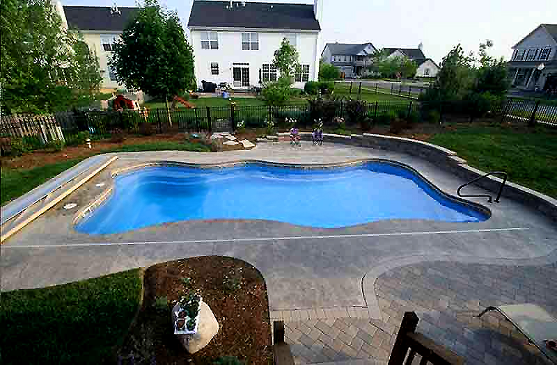 Fiberglass swimming pool with stamped and dyed concrete