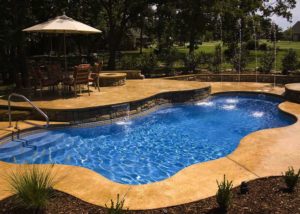 cancun inground swimming pool with stamped and dyed concrete and raised spa