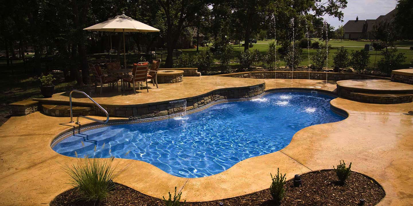 cancun inground swimming pool with stamped and dyed concrete and raised spa